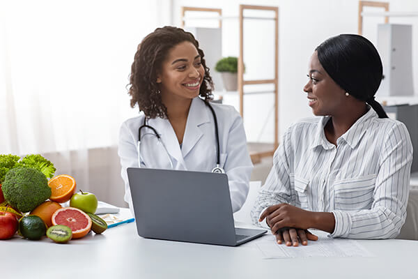 Black women physician chatting with patient