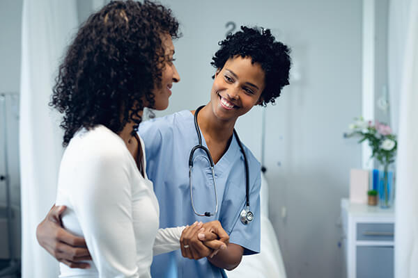 Image of black women physician comforting patient