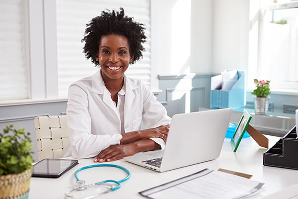 Image of smiling black female doctor looking at camera